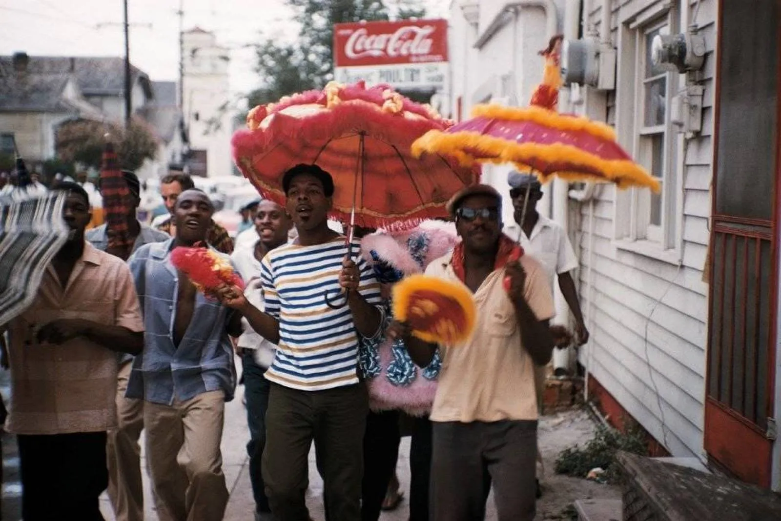 A procissão funerária do cemitério se transforma em uma alegre ocasião e celebração para os mortos com danças nas ruas ao som das bandas de metais de Nova Orleans. (William Claxton)